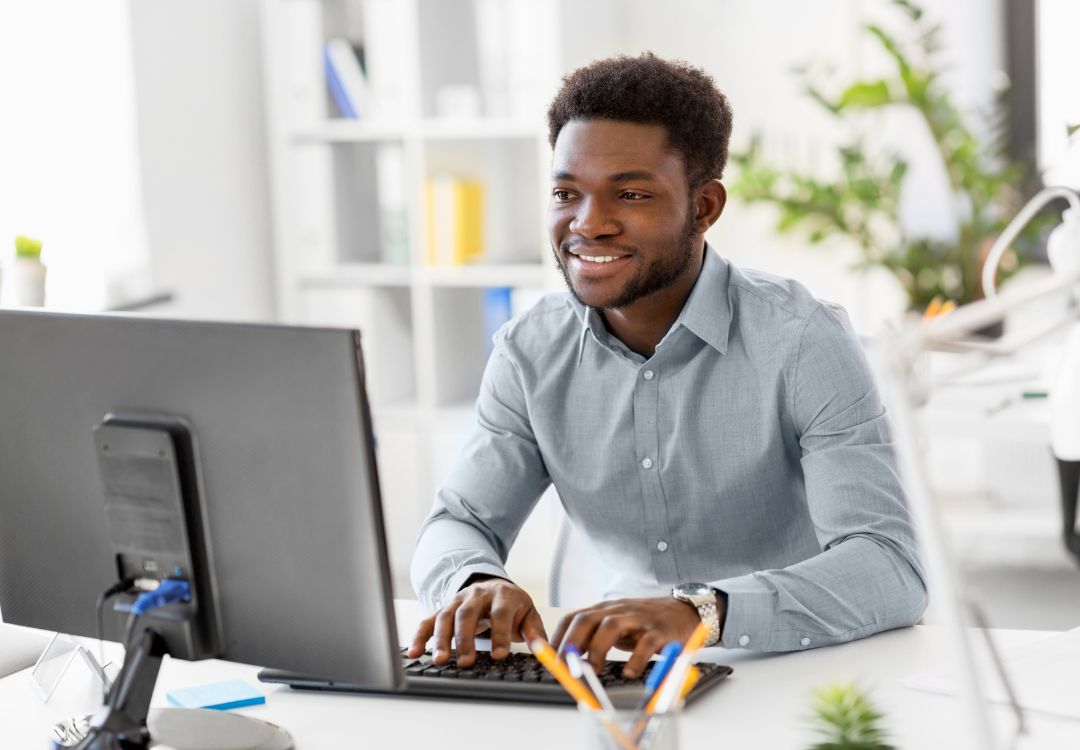 Smiling male student studying holistic functional medicine certificate on computer in bright modern office