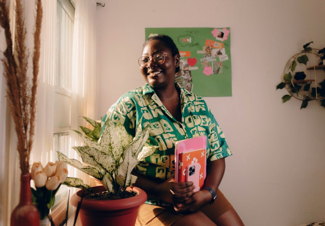 Smiling female student with study materials representing why choose KCNH for natural health doctorate