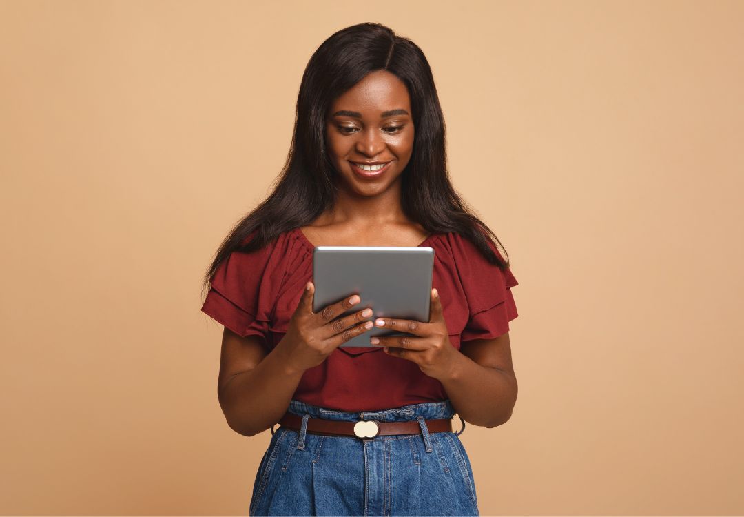 Smiling female student holding tablet studying for natural health certificate program online
