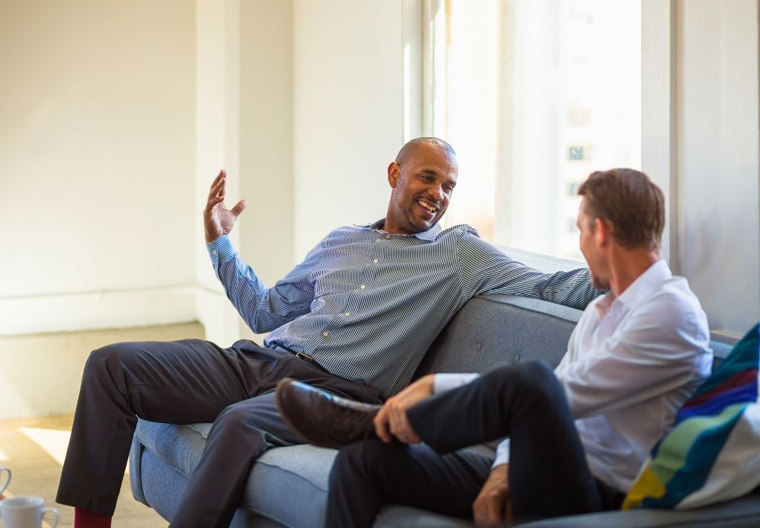 Two male professionals in relaxed discussion representing masters student and mentor in natural health program